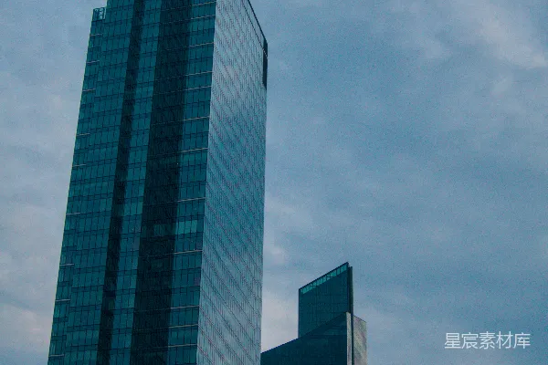 现代玻璃高层建筑矗立在阴云密布的天空下
