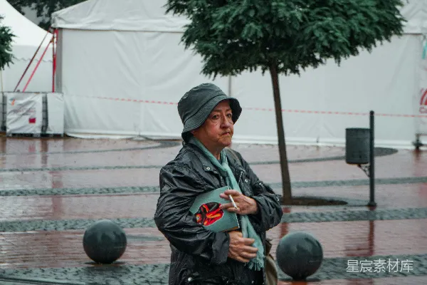 一个男人在雨中打着伞漫步。
