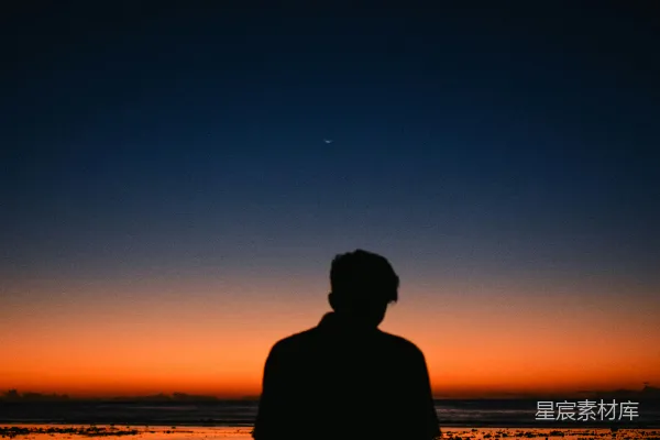 高清摄影 站在海滩上的男人剪影，夕阳西下。