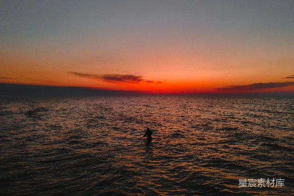 高清摄影 两个剪影在夕阳下的海上。