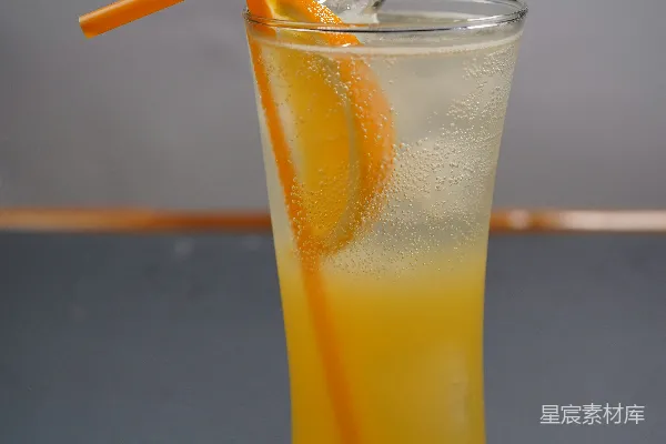 高清摄影 一杯冰镇橙汁，配有冰块和吸管。