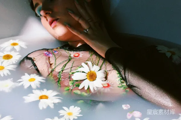 女人躺在浴缸里，漂浮着花朵。