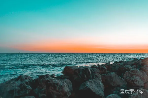夕阳西下，海天相接处有几块岩石。