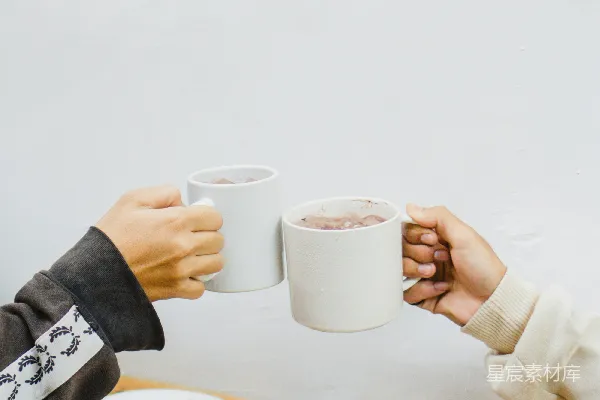 一个坐在桌子旁的人手中拿着一杯咖啡。