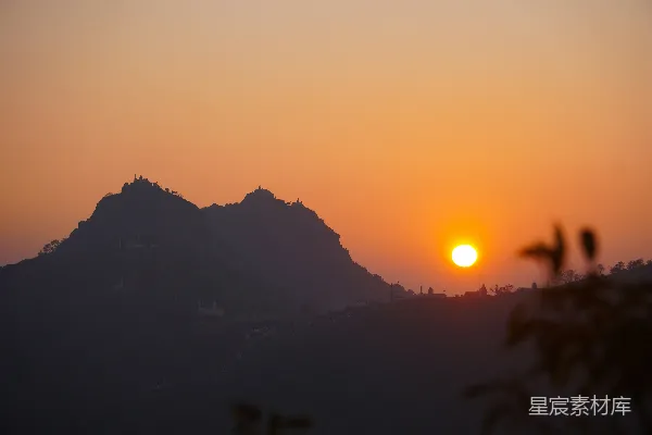 夕阳映照着轮廓分明的山峰暮色中。