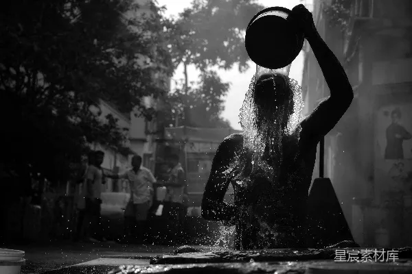 高清摄影 一个女人在雨中，头上顶着一个桶。