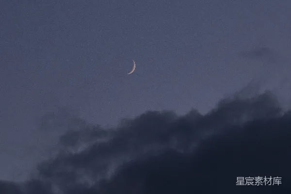 夜空中一轮明月高挂阴云之下。