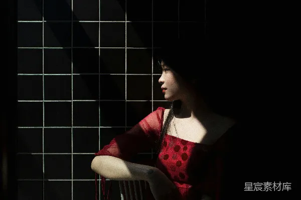 红黑相间的长袖上衣女子坐在椅子上