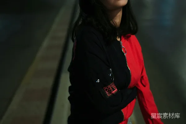 年轻女子站在夜晚的街头。
