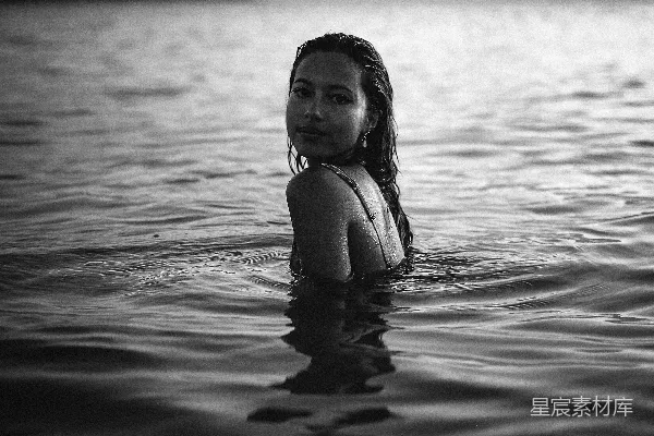 高清摄影 一个女人正在海滩的水里游泳。