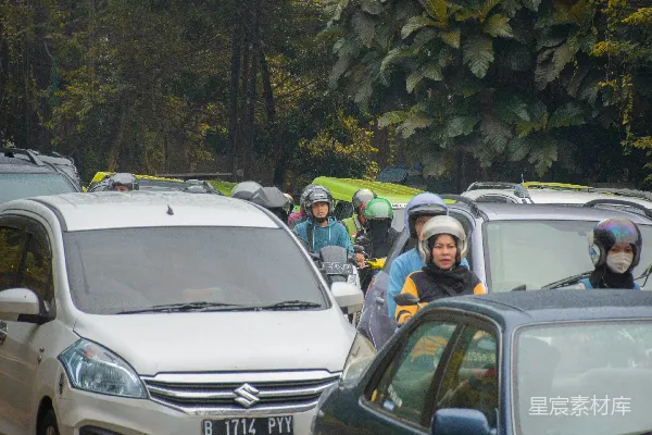 戴着头盔和雨衣的一群人在路上。