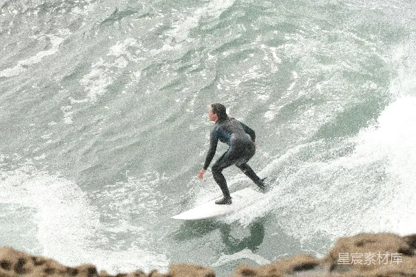 一个男子站在冲浪板上 surfing在波浪之上