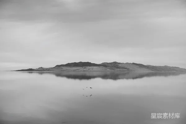 高清摄影 阴云密布的天空下，平静的水面映照着岛屿。
