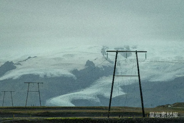 覆盖着白雪的山峰，电力线位于前景。