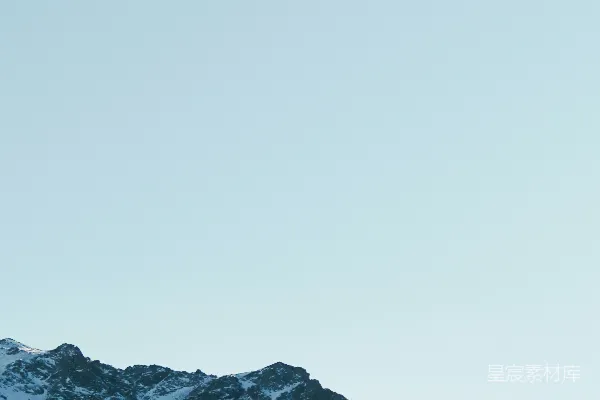 白天雪花覆盖的山峦在皑皑蓝天中