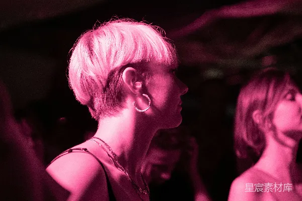 黑色连衣裙的女人站在一间黑暗的房间里。