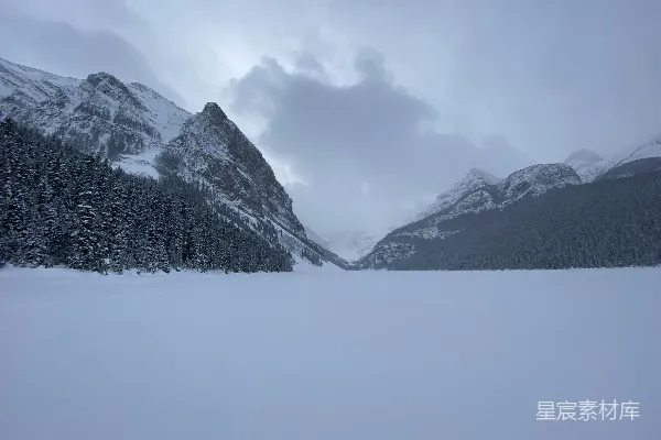 白天云层覆盖下的山被白雪覆盖