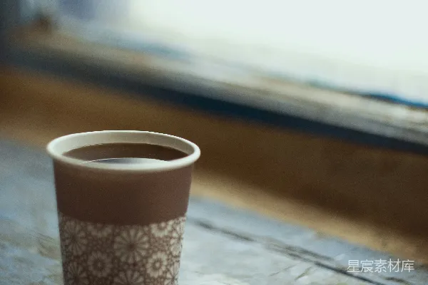 桌子上一杯咖啡和一块饼干。