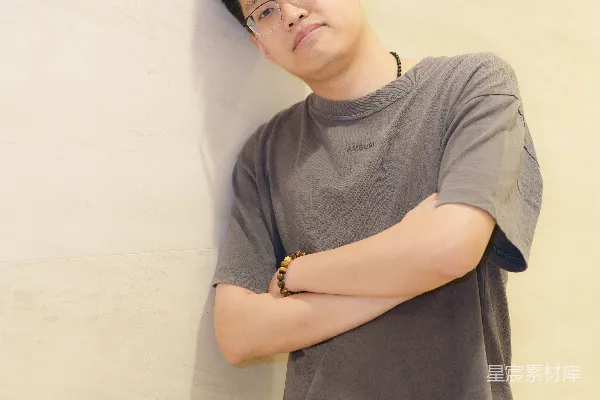 高清摄影 一个男人靠在墙上，双臂交叉。