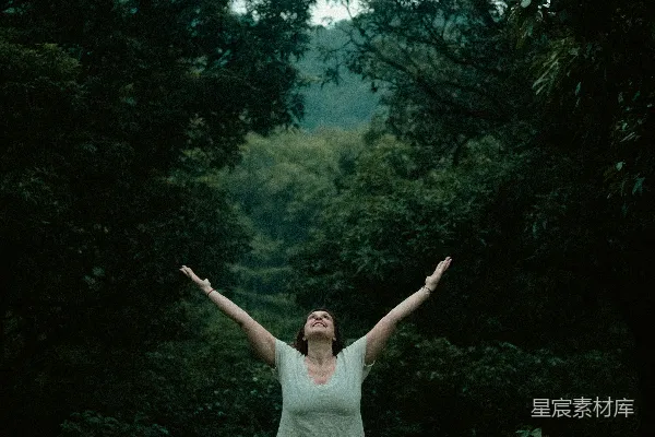 一个女人站在森林的中间。