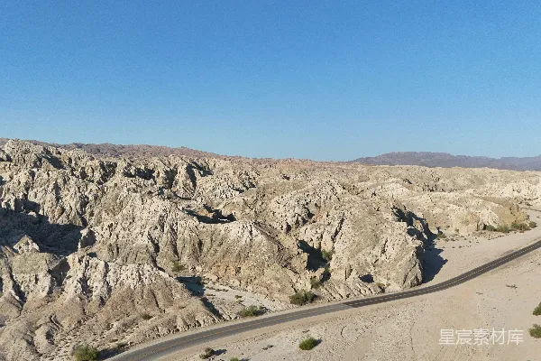 蜿蜒穿过一片荒凉的沙漠峡谷景观的道路