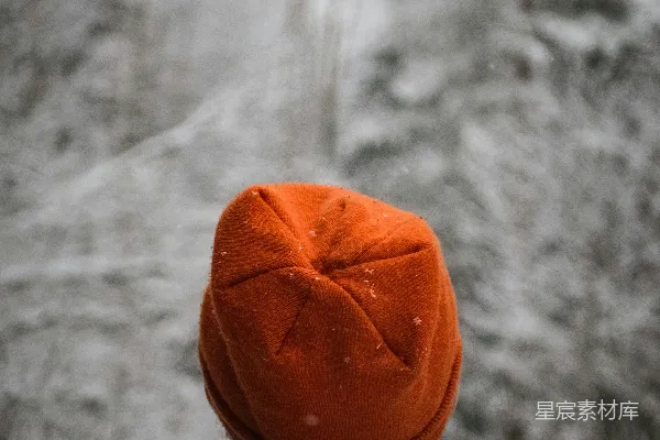 高清摄影 一个戴着橙色帽子的人在雪地里。
