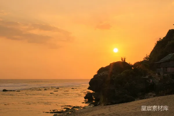 高清摄影 夕阳正缓缓落下，映照在海面上的沙滩上。