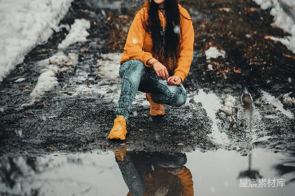 高清摄影 一个女人坐在雪中的岩石上