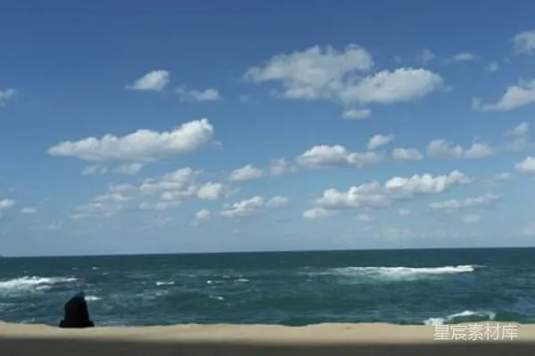 海边坐着的人望着大海中的景象。