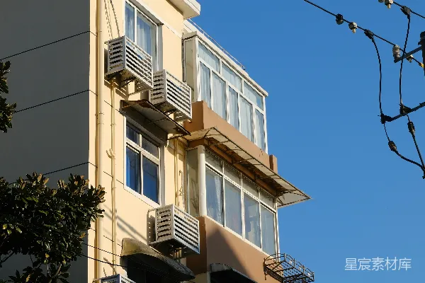 一栋高大的建筑有多个窗户和空调外机。