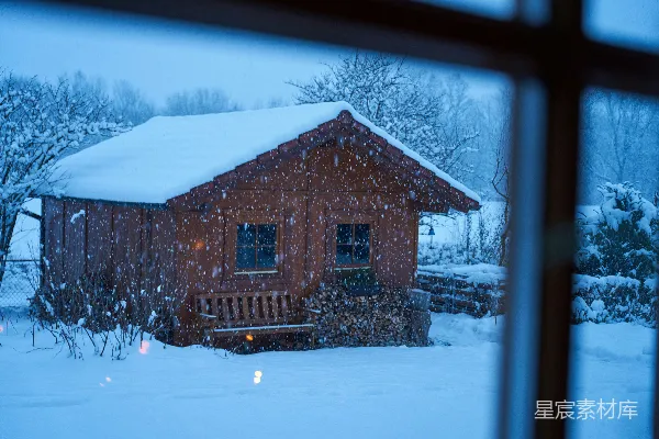 透过窗户看到的雪地小屋