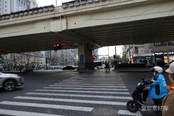一个城市交叉路口，车辆和行人穿梭其间。