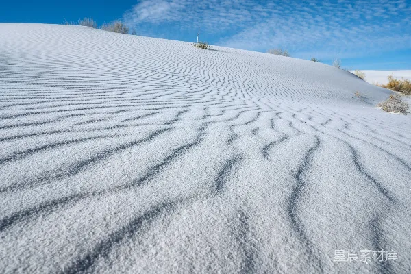 背景是蓝天覆盖着一座白雪皑皑的山丘。
