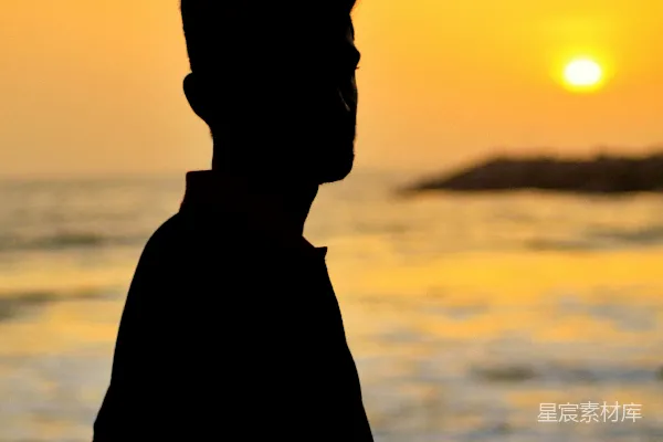 高清摄影 剪影中的男人站在海边。