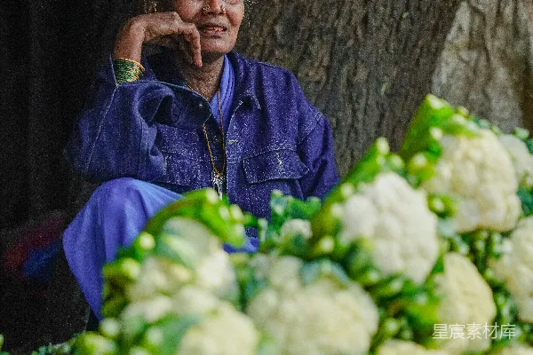 一位妇女坐在树前打电话。