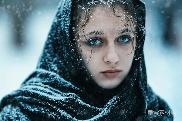 高清摄影 一个蓝眼睛的女人被雪覆盖着。