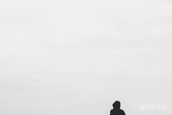 高清摄影 一个穿着连帽衫的男人站在雪覆盖的田野上，白天。