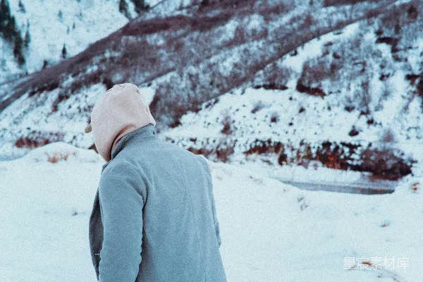 高清摄影 一个男人站在雪地里，穿着一件连帽衫。