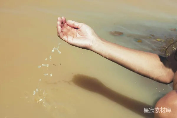 手让水滴入泥泞的水洼中。