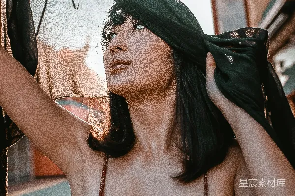黑白花卉款式白背心的女士正在手持黑色布料。