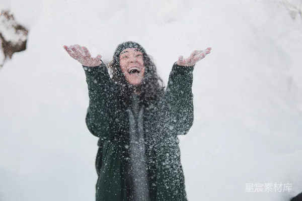 高清摄影 一个女人站在雪地里，双臂伸展。