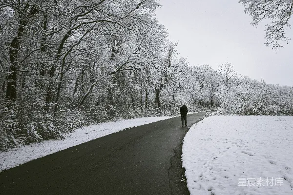 高清摄影 一个人走在有雪的一侧的路上。