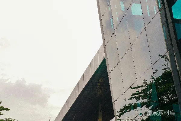 现代玻璃建筑映射着树木和天空