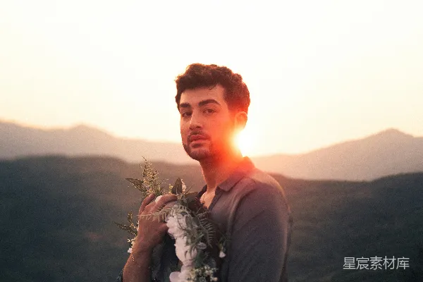 黑色长袖衬衫的男人手持一束花