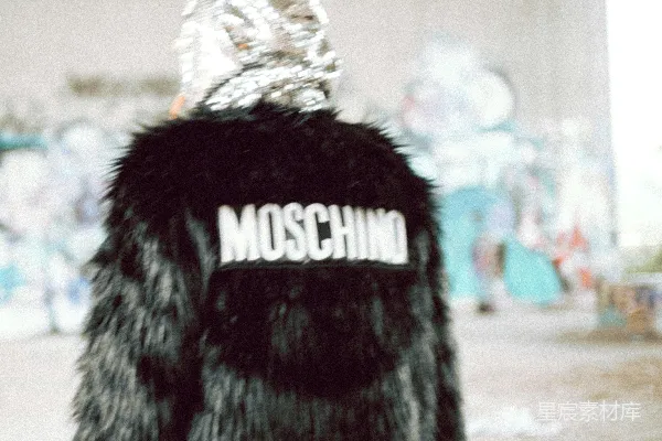 一件黑色皮草外套上绣有Moschino字样的一位女性