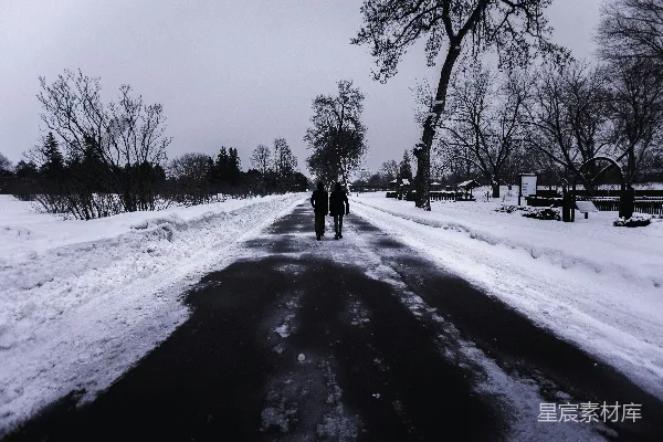 高清摄影 两个人走在一条被雪覆盖的小路上