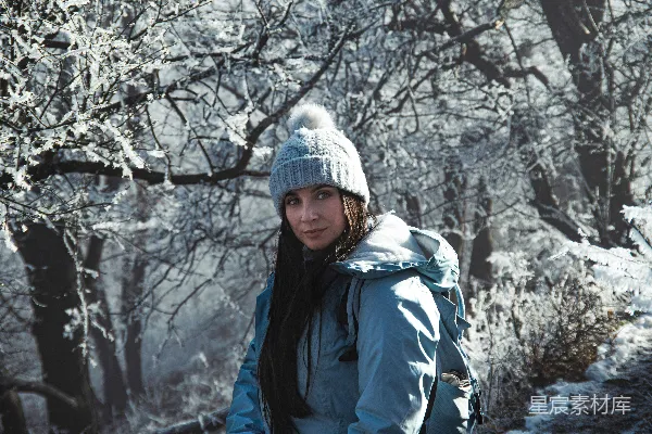 高清摄影 一个站在雪地里的女人，手里拿着滑雪板。
