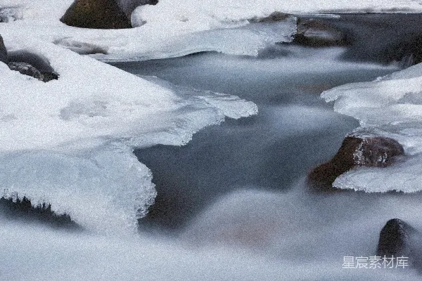 高清摄影 一条被雪覆盖的岩石环绕的水流