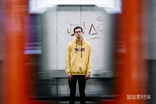 穿着棕色夹克的男人站在白色和红色建筑前