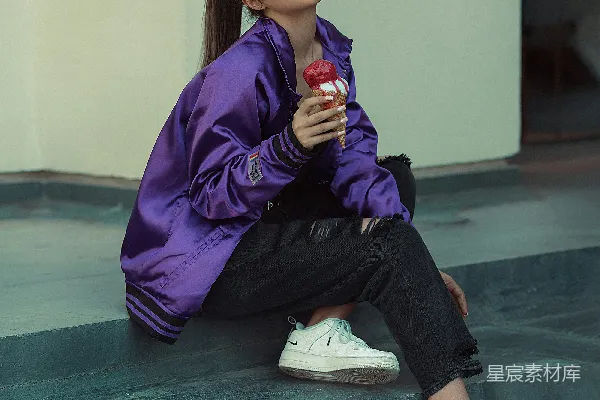 一个女人坐在地上，手里拿着一杯酒。